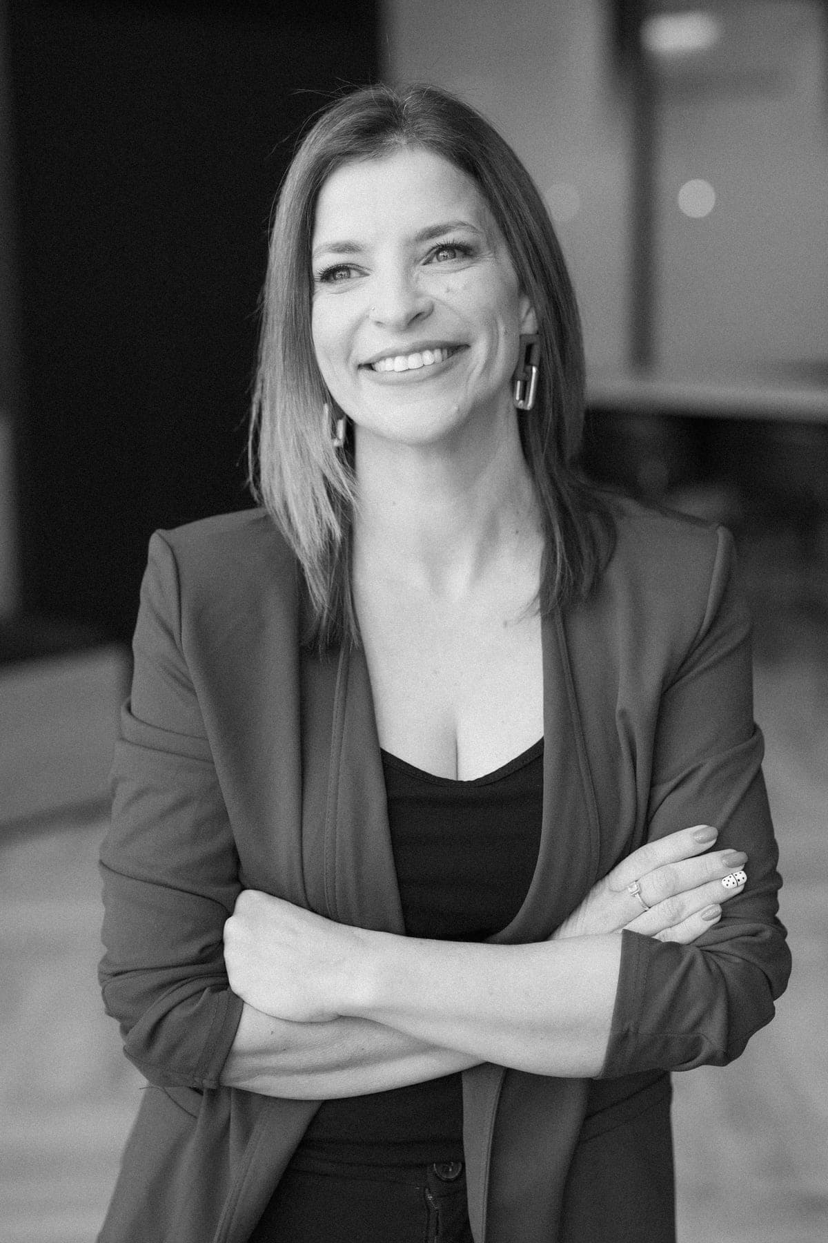 Black-and-white portrait of Ady Mor-Biran with arms crossed, smiling.